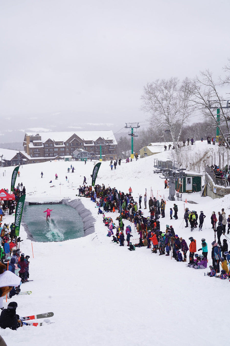 At Burke Mountain, VT, the last person standing wins the annual pond skim. An unknown skier does their best to stay afloat as judges and spectators look on. Photo: Amanda Anderson