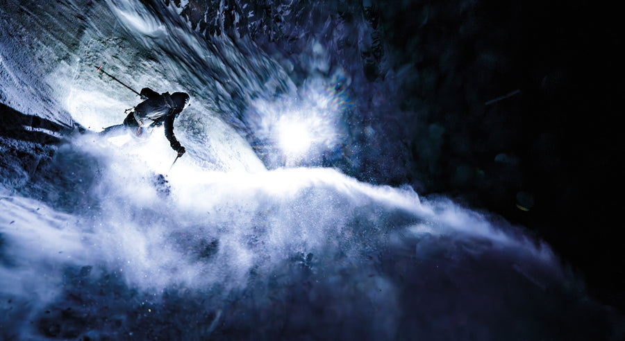 Madison Rose Ostergren forgoes the second rappel and charges over the cave in the Apocalypse Couloir in the Teton Range, while Jim Ryan, Erich Roepke, and Clayton Hermann light up the rock walls with their headlamps. Photo: Clayton Herrmann