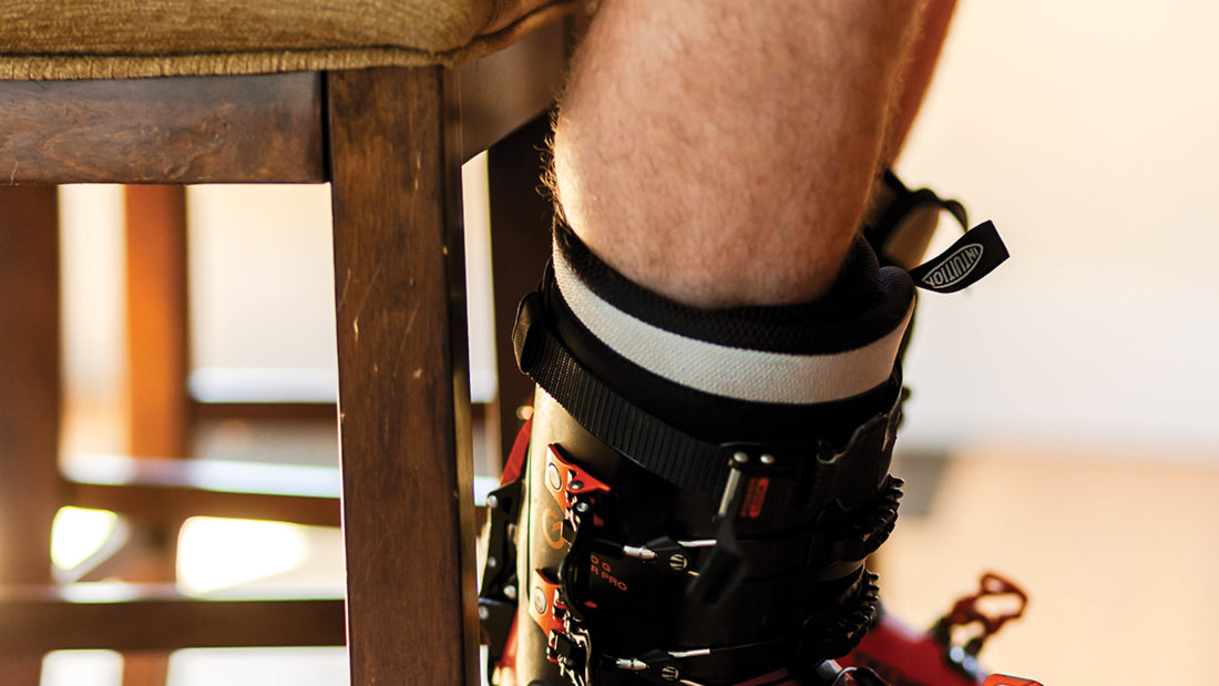 Man sitting on a stool with bare legs and ski boots. Photo: Katie Lozancich