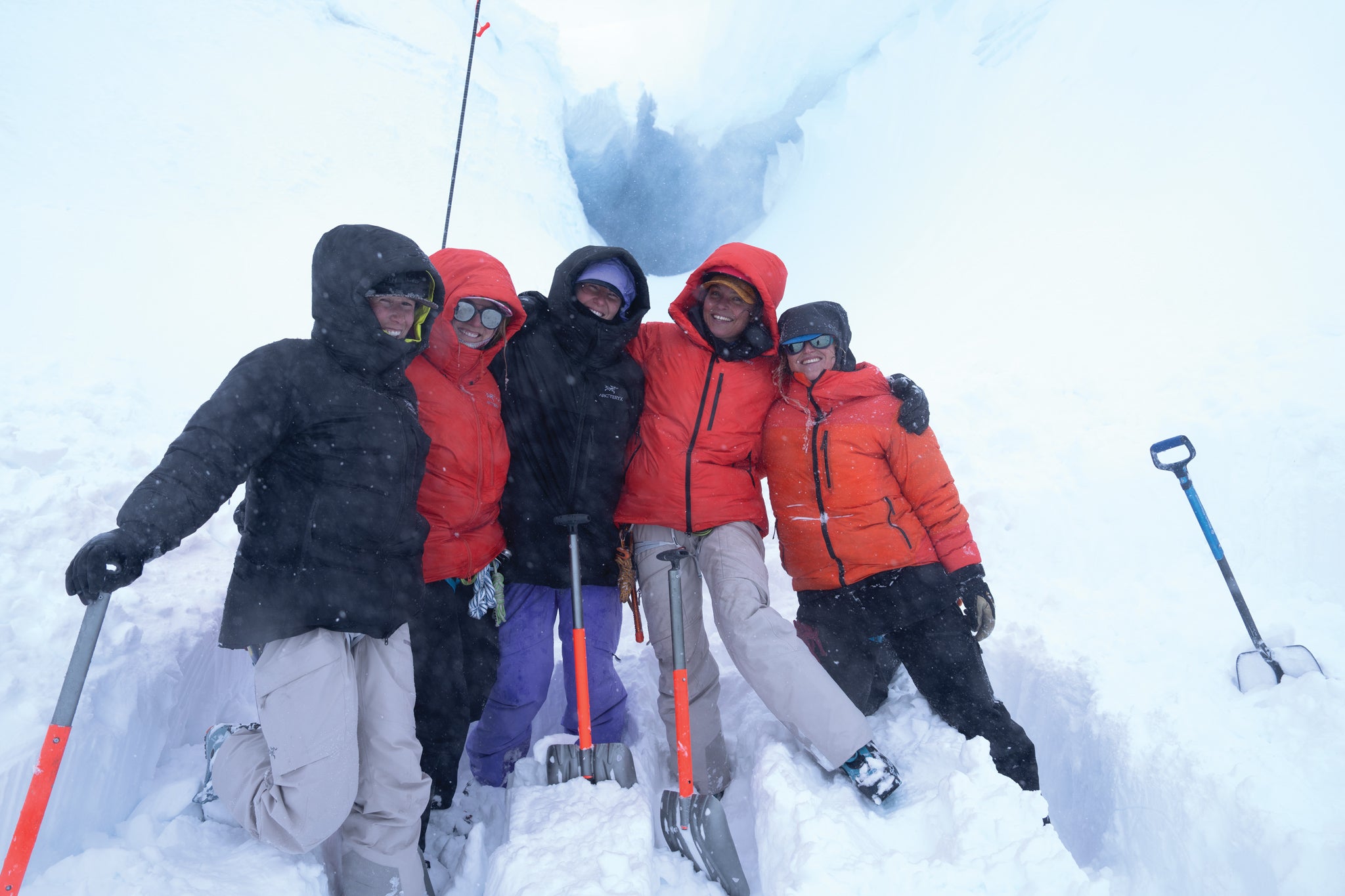 Women of Winter. Group of people in winter clothing with ice axes and shovels in a snowy environment